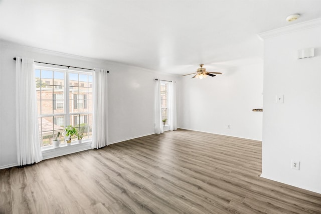 unfurnished living room featuring crown molding, ceiling fan, and light hardwood / wood-style flooring