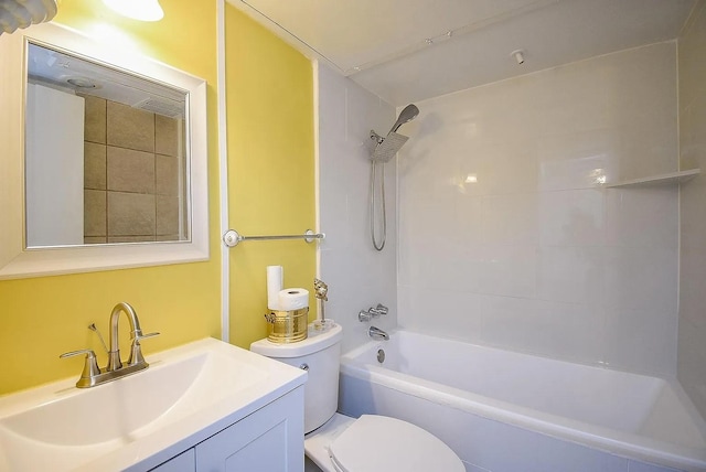 full bathroom with tiled shower / bath, vanity, and toilet