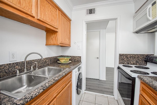 kitchen featuring sink, crown molding, light tile patterned floors, electric range oven, and washer / dryer