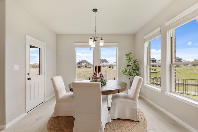 dining space with light wood-type flooring and a notable chandelier