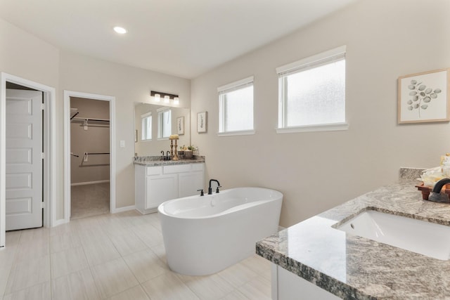 bathroom with a washtub and vanity