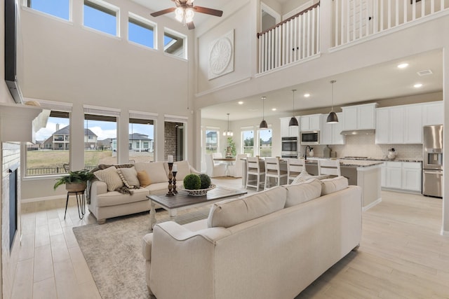 living room featuring ceiling fan, sink, and light hardwood / wood-style floors