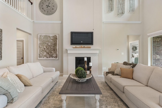 living room with a high ceiling and a brick fireplace