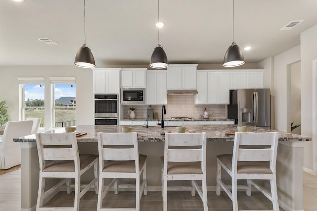 286 Peninsula Point Dr, Montgomery, TX 77356 - kitchen featuring appliances with stainless steel finishes, a large island, tasteful backsplash, white cabinets, and recessed lighting