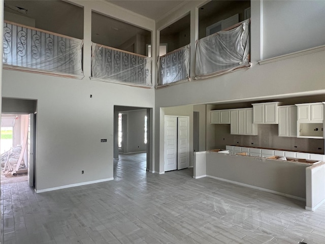 286 Peninsula Point Dr, Montgomery, TX 77356 - kitchen featuring a towering ceiling, light wood-style floors, a center island, and white cabinetry