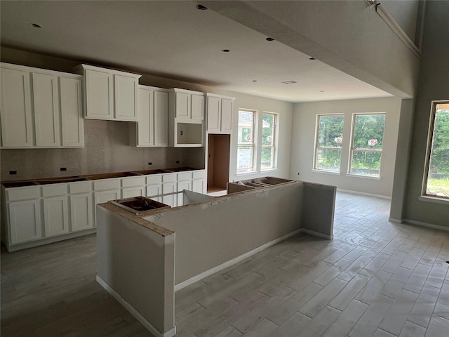 286 Peninsula Point Dr, Montgomery, TX 77356 - kitchen featuring a kitchen island, tasteful backsplash, white cabinetry, and light wood-type flooring