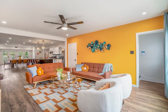 living room featuring ceiling fan and light hardwood / wood-style flooring