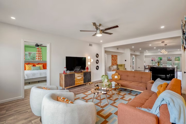 living room with ceiling fan and light hardwood / wood-style flooring