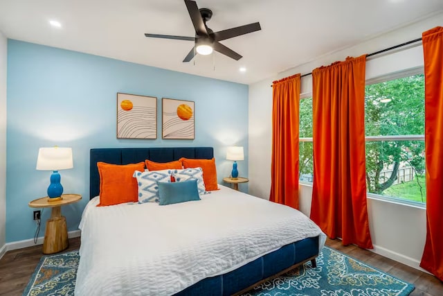 bedroom with multiple windows, hardwood / wood-style floors, and ceiling fan