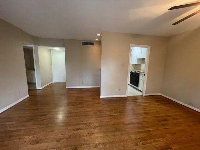 unfurnished living room featuring dark hardwood / wood-style flooring and ceiling fan