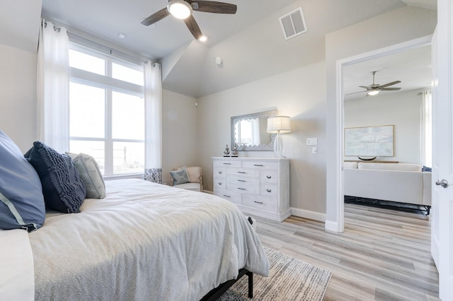 bedroom featuring vaulted ceiling, visible vents, and multiple windows