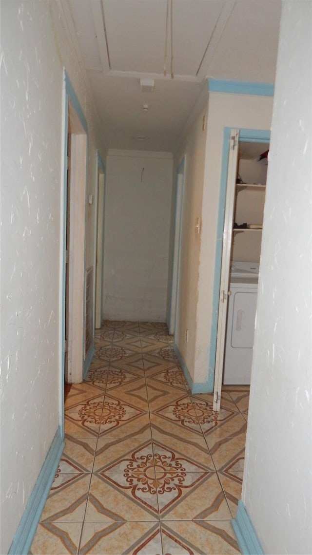 corridor featuring washer / dryer and light tile patterned floors