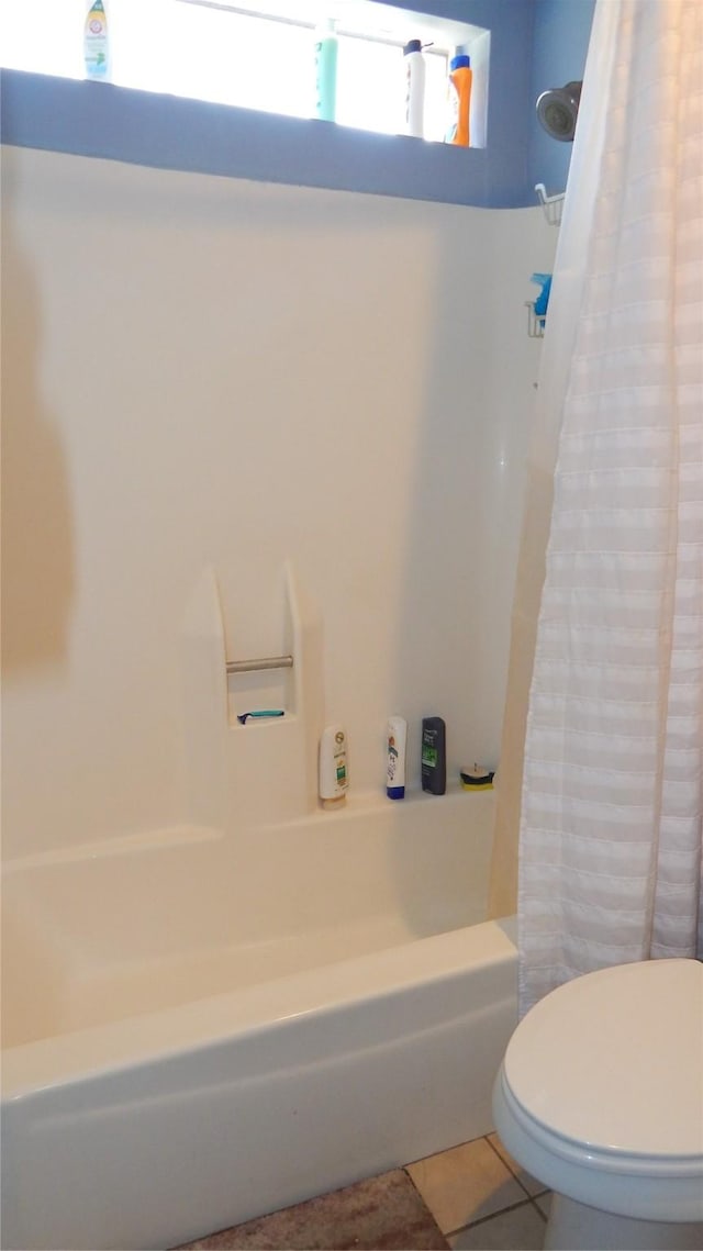 bathroom featuring shower / tub combo with curtain, tile patterned floors, and toilet