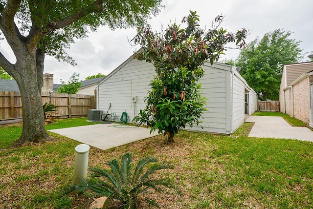 back of house with central AC, a lawn, and a patio