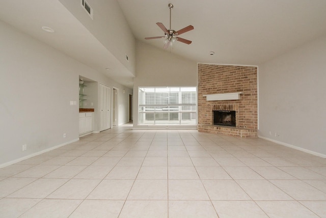 unfurnished living room with ceiling fan, high vaulted ceiling, a brick fireplace, and light tile patterned floors