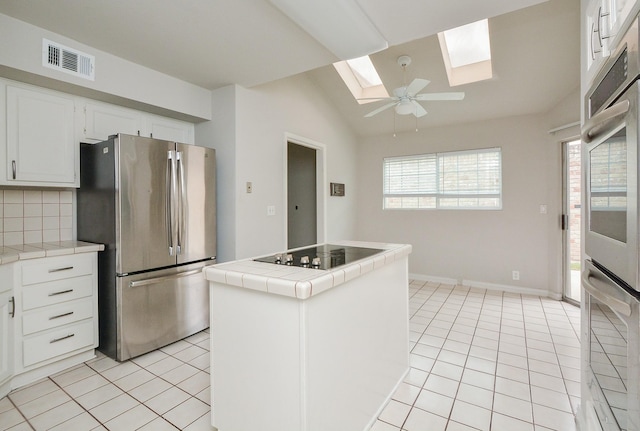 kitchen featuring white cabinetry, appliances with stainless steel finishes, tile counters, and light tile patterned floors