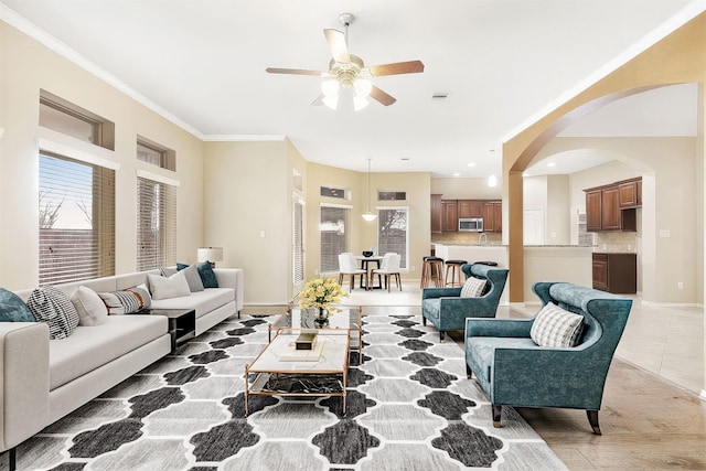 living room with tile patterned floors, ceiling fan, and ornamental molding