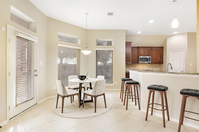 tiled dining room featuring sink