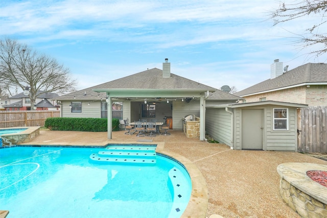 view of pool featuring an in ground hot tub, ceiling fan, a shed, and a patio