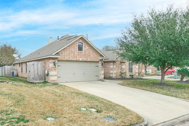 view of front of house featuring cooling unit, a garage, and a front yard