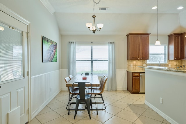 tiled dining room featuring vaulted ceiling, sink, a wealth of natural light, and a notable chandelier