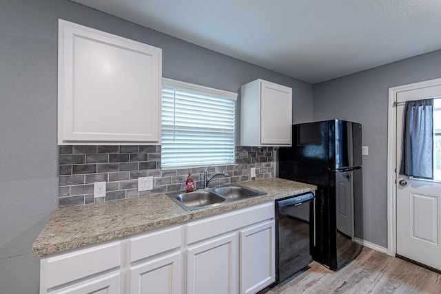 kitchen featuring sink, decorative backsplash, black appliances, and white cabinets