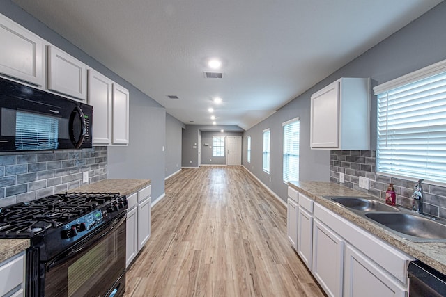 kitchen with sink, tasteful backsplash, black appliances, light hardwood / wood-style floors, and white cabinets