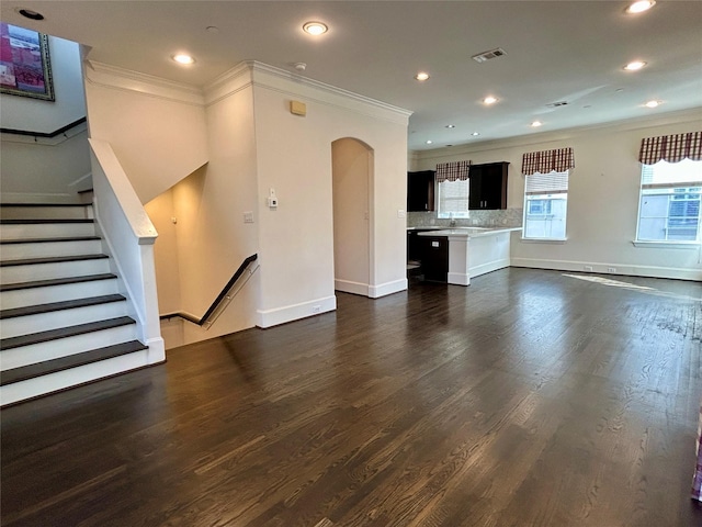 unfurnished living room with crown molding and dark hardwood / wood-style flooring