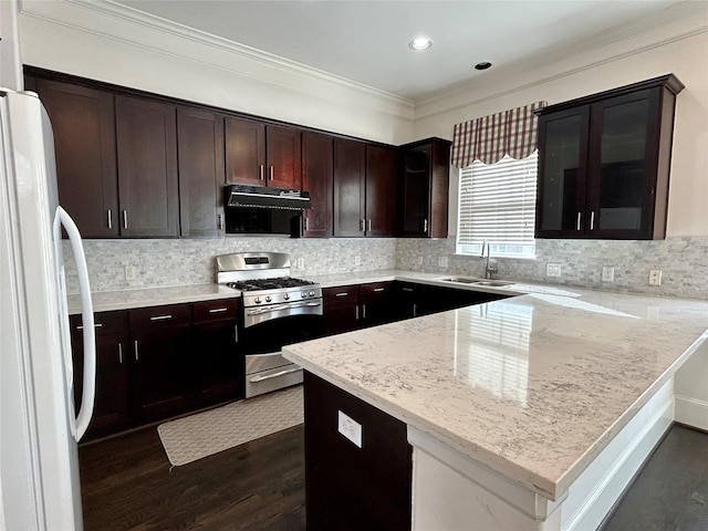 kitchen featuring extractor fan, sink, gas range, light stone counters, and white refrigerator