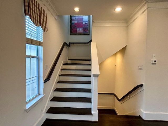 stairway with ornamental molding and hardwood / wood-style floors