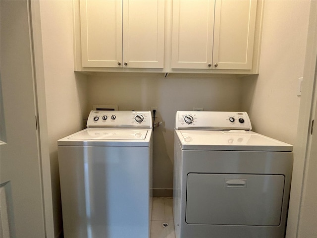 washroom featuring cabinets and washing machine and clothes dryer