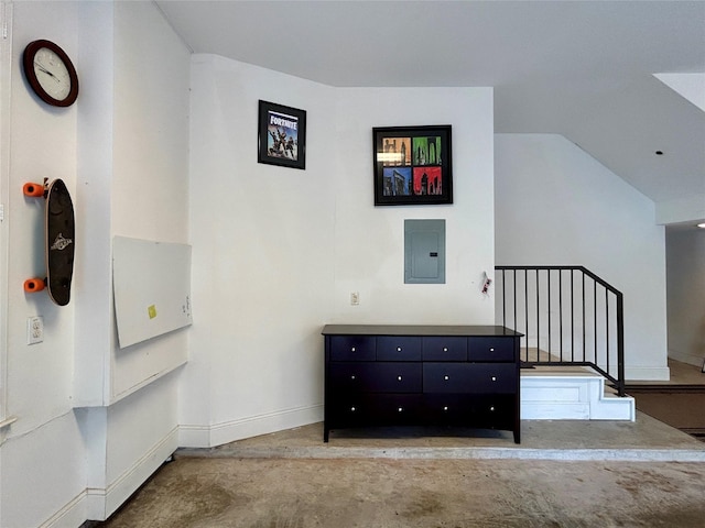 interior space featuring lofted ceiling, electric panel, and concrete floors