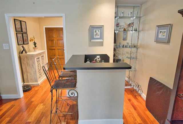 dining space featuring hardwood / wood-style flooring and indoor bar