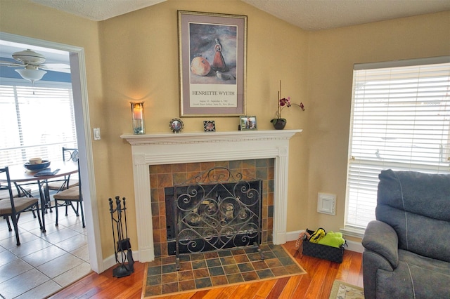 sitting room with hardwood / wood-style flooring, lofted ceiling, a healthy amount of sunlight, and a fireplace