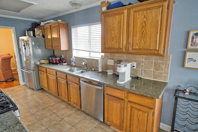 kitchen featuring appliances with stainless steel finishes, sink, backsplash, light tile patterned floors, and crown molding