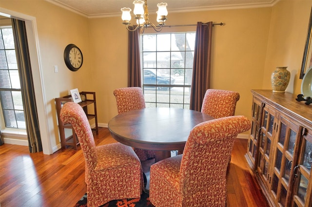 dining area with crown molding, wood-type flooring, and a chandelier