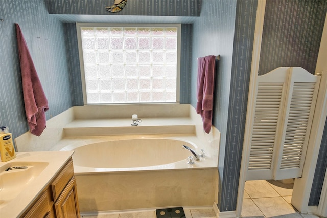 bathroom with tile patterned floors, a bath, and vanity