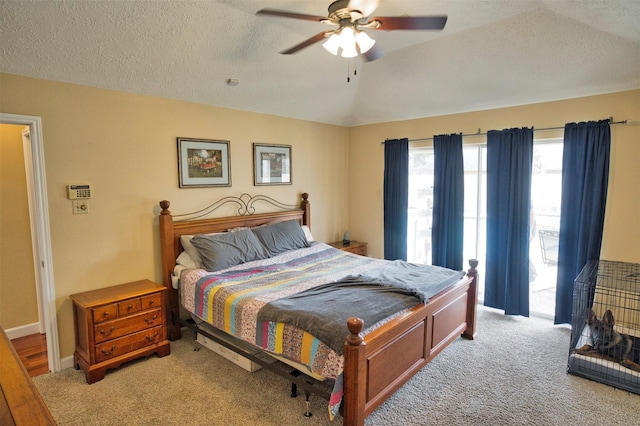 bedroom featuring ceiling fan, lofted ceiling, access to exterior, and a textured ceiling