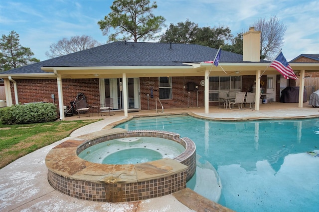 view of swimming pool featuring an in ground hot tub and a patio area