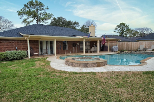 view of pool with an in ground hot tub, a yard, and a patio