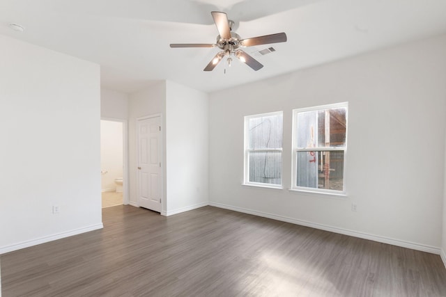 spare room with dark wood-type flooring and ceiling fan