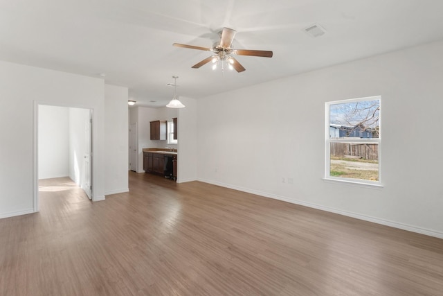 unfurnished living room with ceiling fan and light wood-type flooring