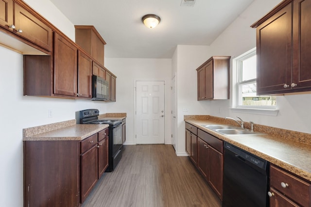 kitchen featuring dark wood-type flooring, sink, and black appliances