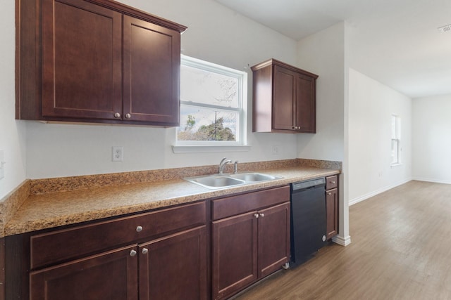 kitchen with light hardwood / wood-style floors, black dishwasher, and sink