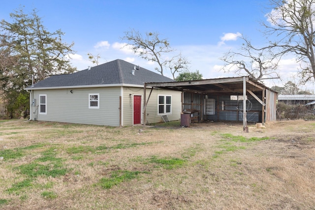 rear view of house featuring a yard and an outdoor structure