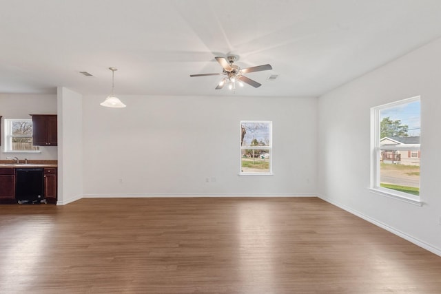 spare room featuring dark wood-type flooring, sink, and a wealth of natural light