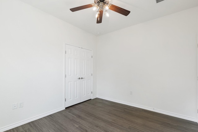 unfurnished room featuring dark wood-type flooring and ceiling fan