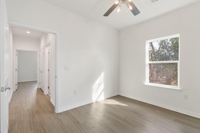 empty room featuring ceiling fan and light hardwood / wood-style flooring