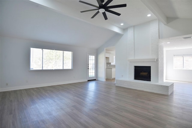 unfurnished living room with ceiling fan, dark wood-type flooring, a fireplace, and beam ceiling