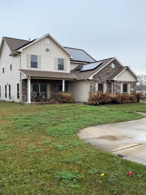 view of front of house with a front lawn and solar panels